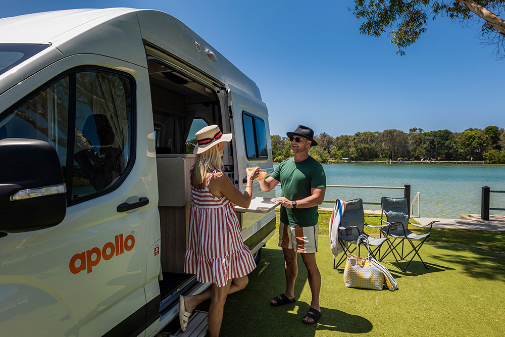 A couple beside their Apollo campervan.