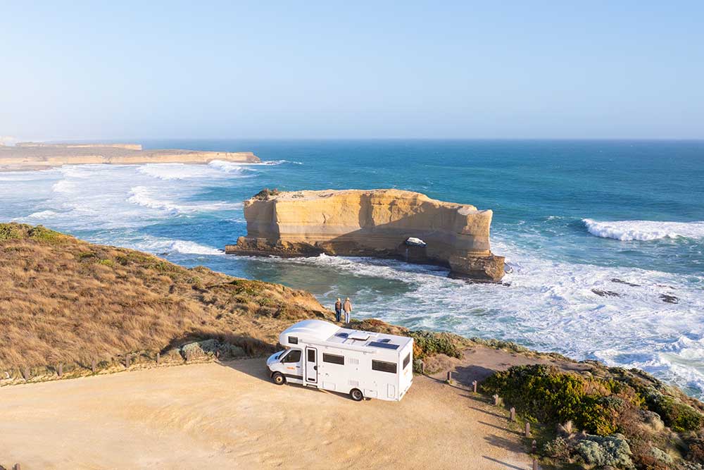 Campervan parked at edge of cliff overlooking sea view on Great Ocean Road.
