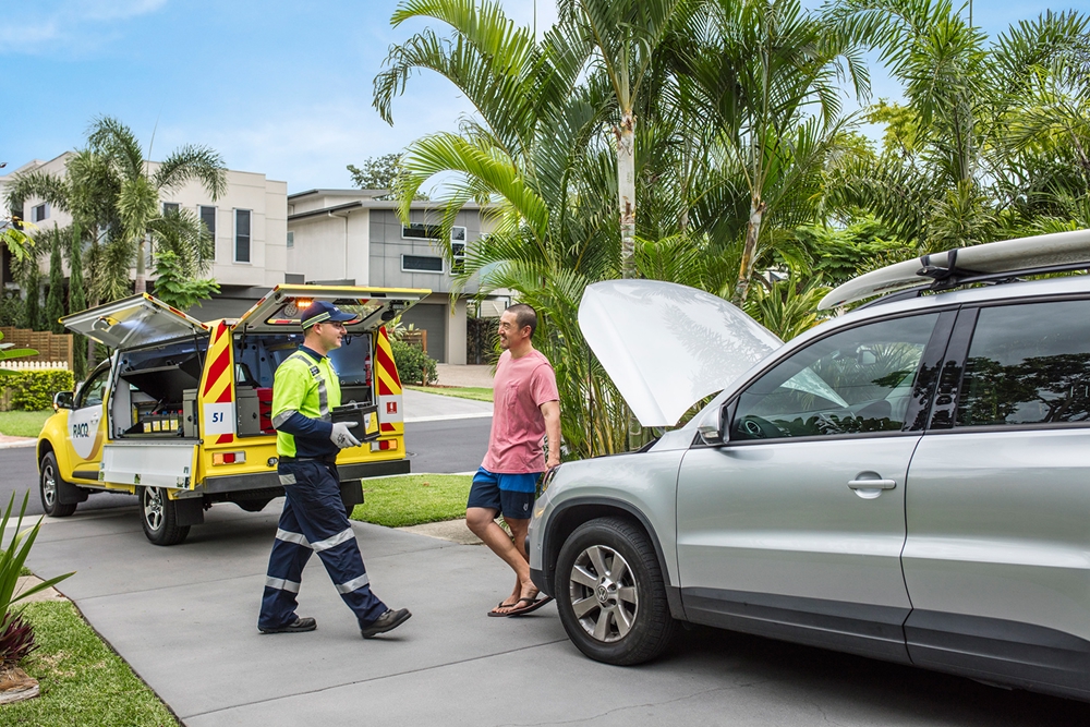 roadside assistance helping driver with his broken-down car on his driveway 