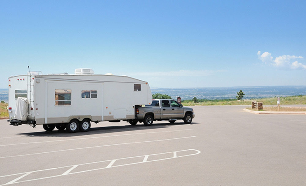 Ute with a large caravan parked in a carpark.