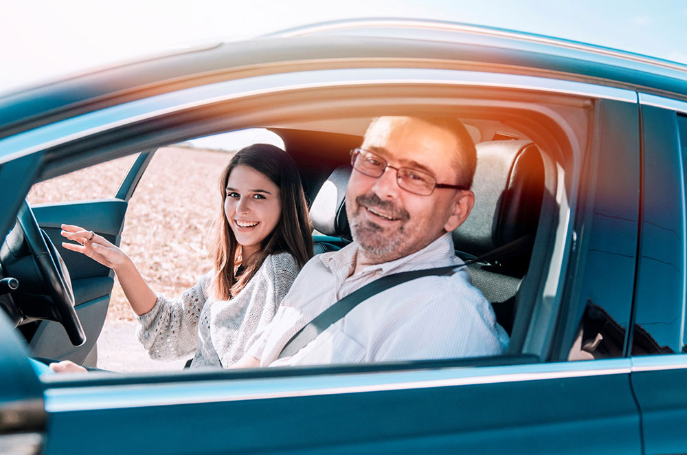 Father gives daughter driving lesson.