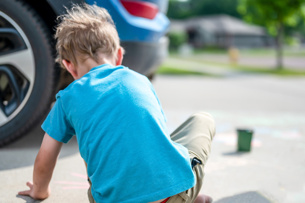 Child playing in a driveway.