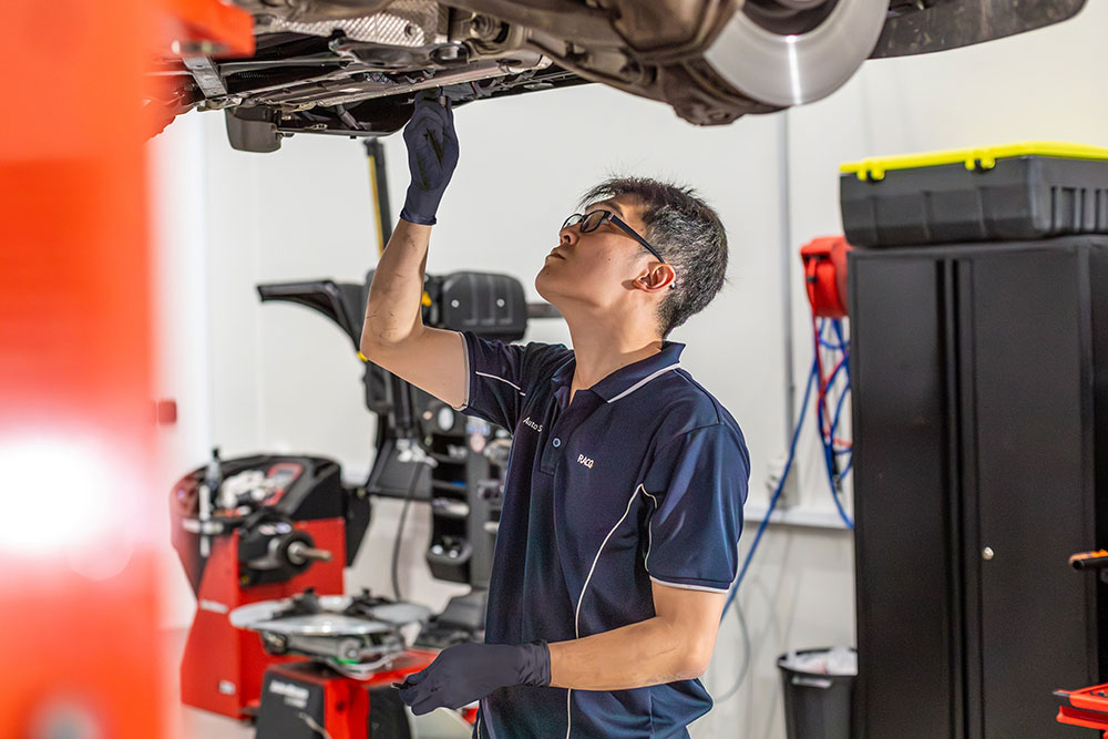 RACQ Auto employee working on a car.