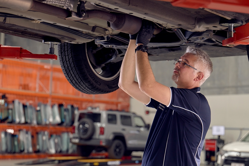 RACQ Auto employee working on a car.