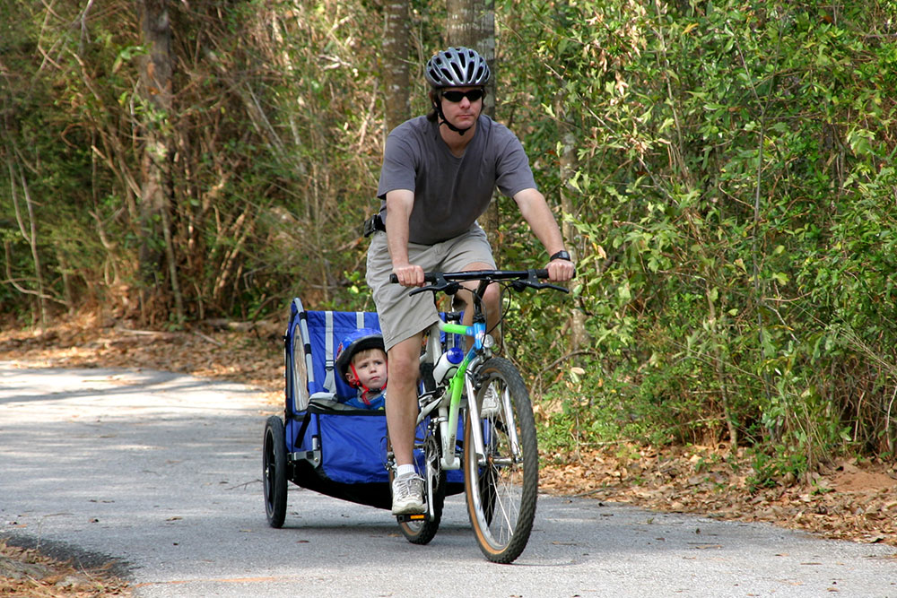 Cyclist towing child.