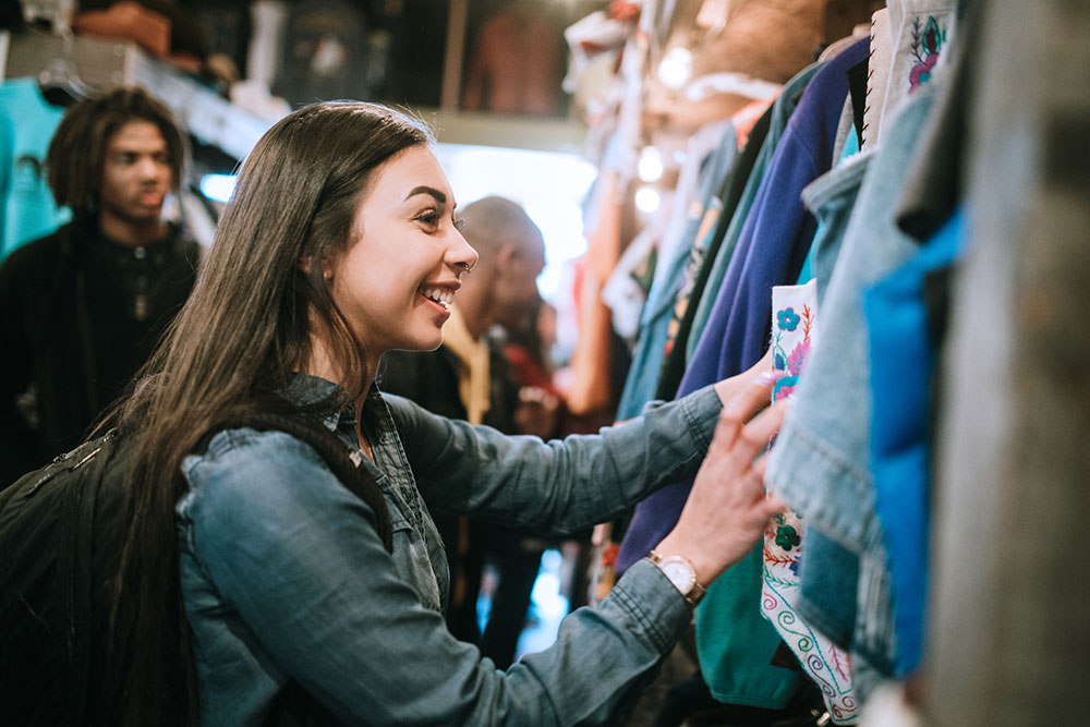 Young woman shopping for second-hand clothes.
