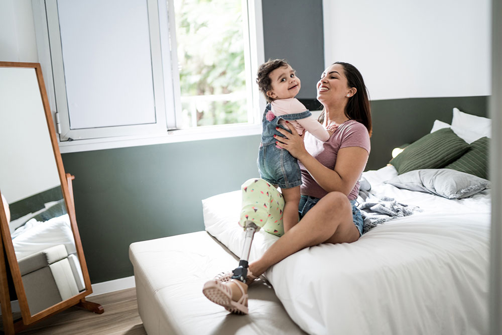 Disabled mother with child sitting on bed