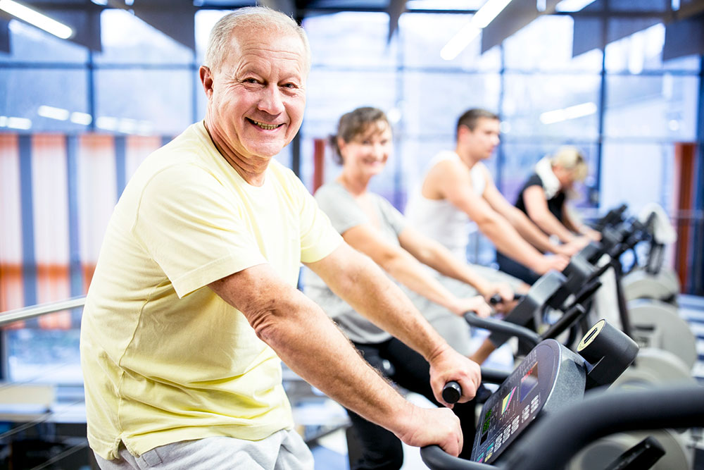 A senior man on an exercise bike.