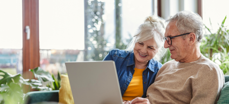 Senior couple using laptop while sitting on sofa