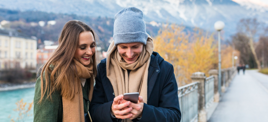 young couple looking at phone overseas on holiday