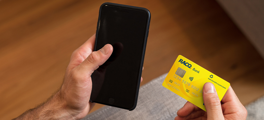 hand holding phone and racq bank visa card