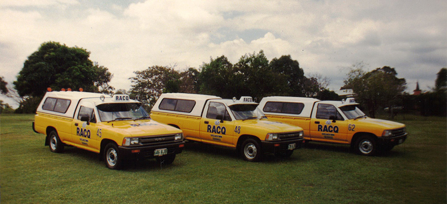 Historical yellow RACQ roadside patrols on grass