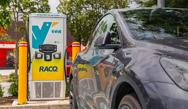 Car parked in front of Evie and RACQ branded electric vehicle charger