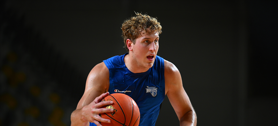 Brisbane Bullets player dribbling basketball wearing team jersey