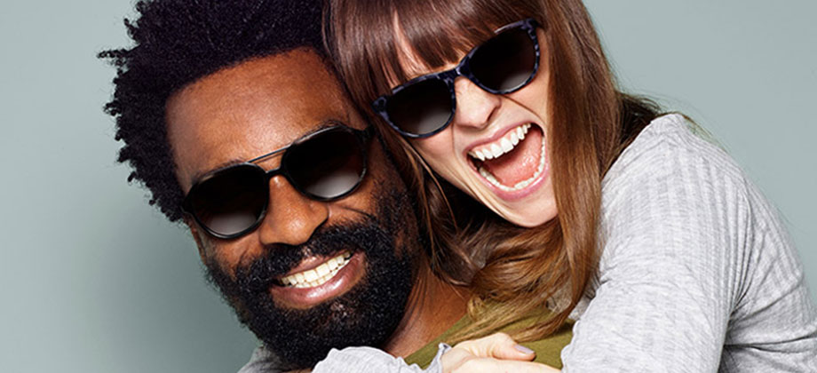 Couple with sunglasses hugging and smiling