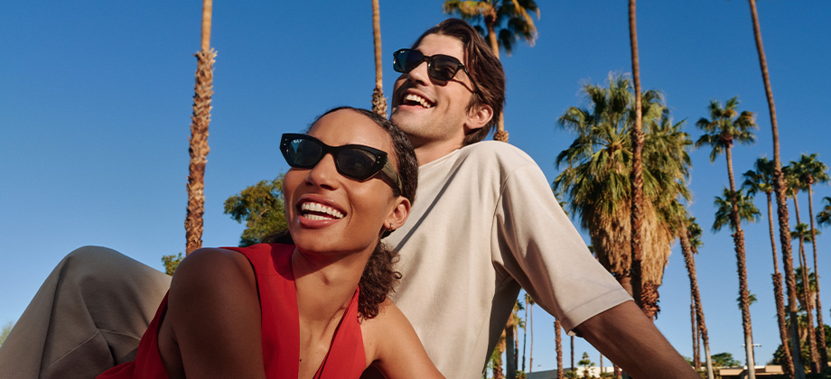sunglass hut man and woman laying in the sun smiling
