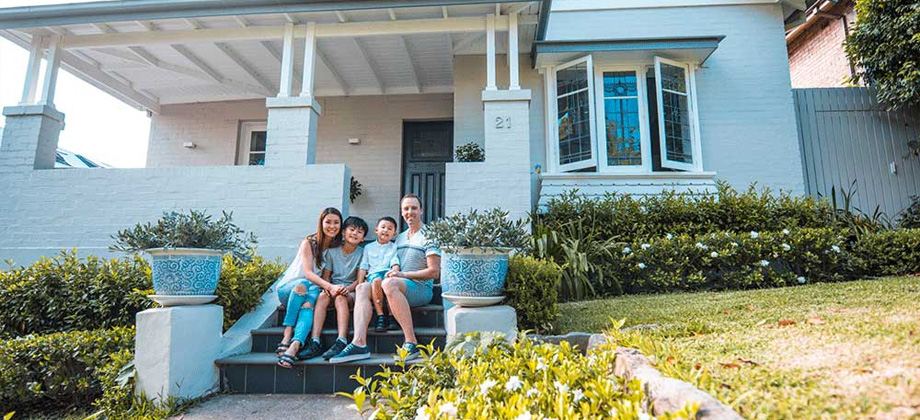 Family sitting on house steps 920x420