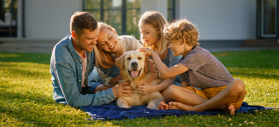 Happy family on grass with their pet dog