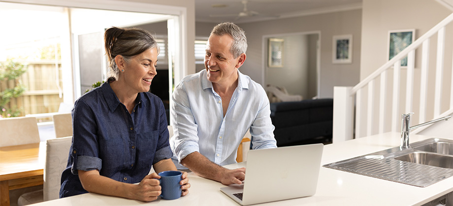 senior couple working on laptop in kitchen 920x420