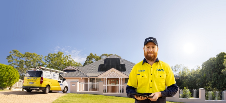 Solar mechanic in front of house with solar panels