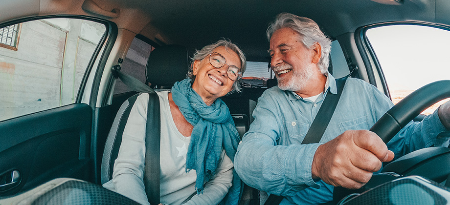 seniors couple in car smiling