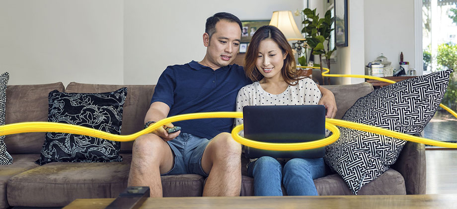 Couple on sofa looking at laptop