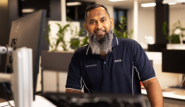 RACQ technology staff member at computer in office