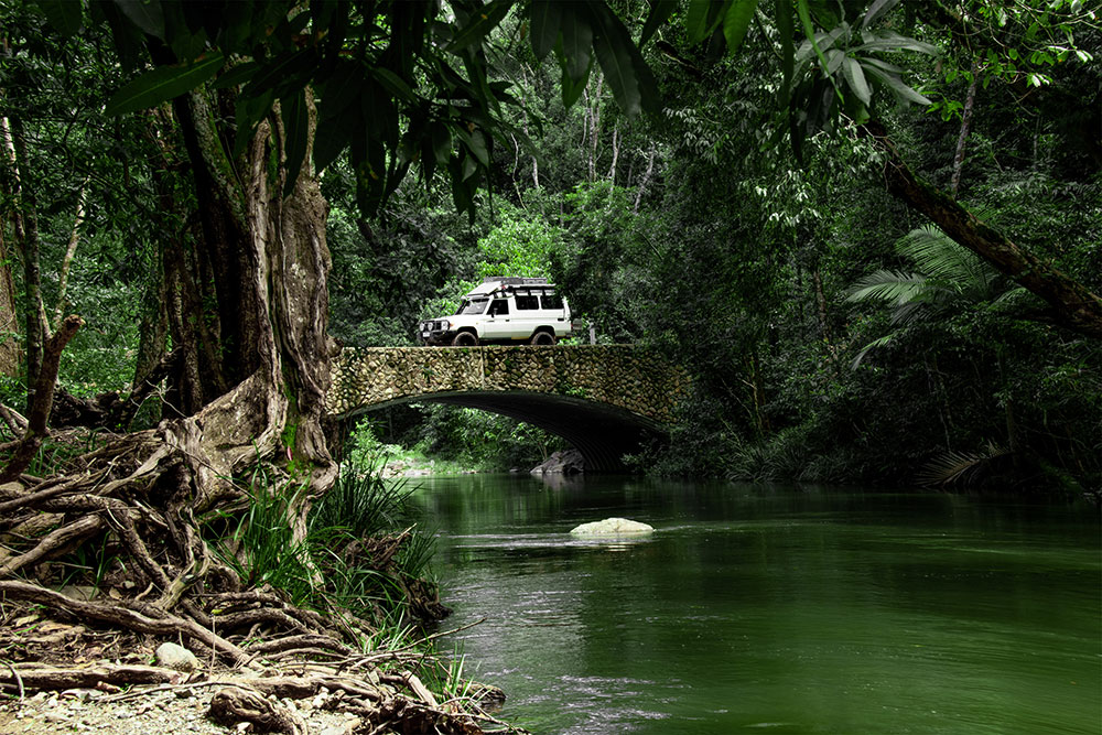 A four-wheel-drive vehicle drives over a bridge on the Bloomfield Track.