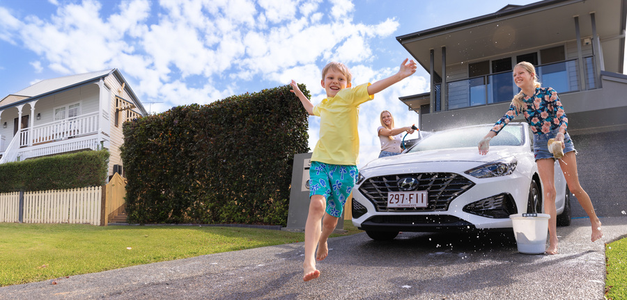 Young family washing car in the driveway