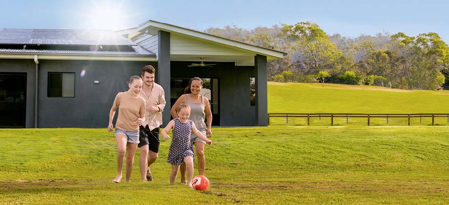 Family playing in front of solar house