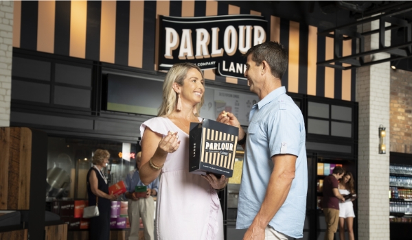 Couple in front of movie theatre with popcorn