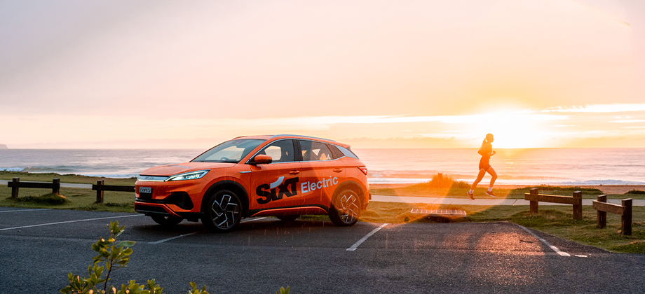 sixt car with person running at beach